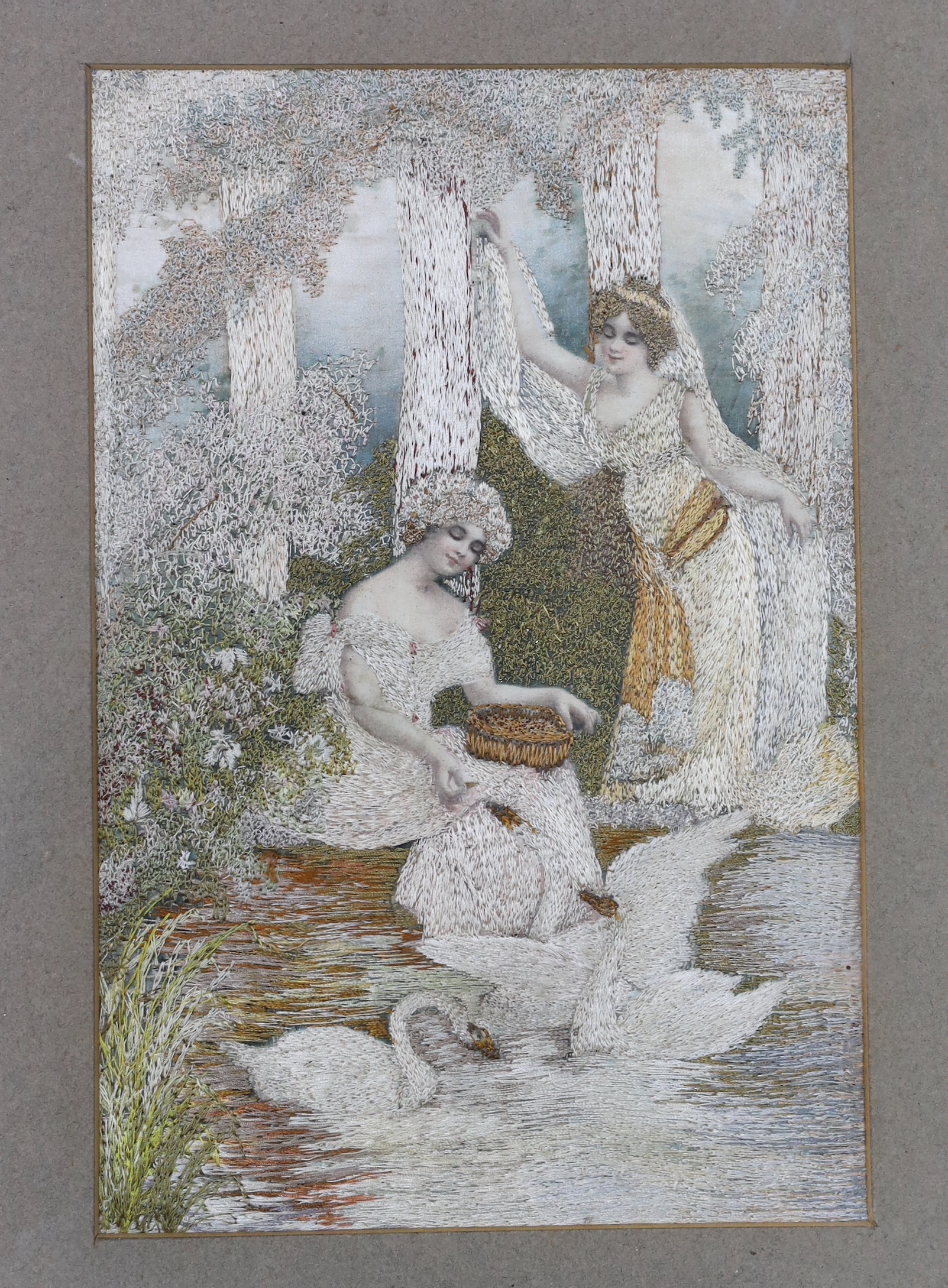 A pair of framed silk needlework panels, one of two ladies feeding a swan, the other of them cutting flowers in a garden, 13.5cm wide x 22.5cm high